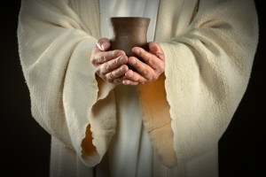 The hands of Jesus holding wine cup, symbol of communion